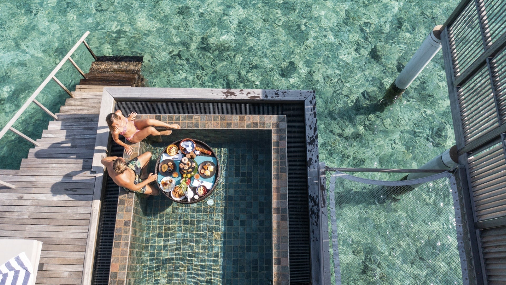 Couple prenant un petit-déjeuner dans une piscine